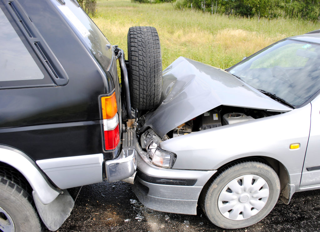 Small silver car rammed into back of black SUV, crunching the front end of the silver car